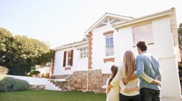 Welcome home. A family standing outdoors admiring their new home