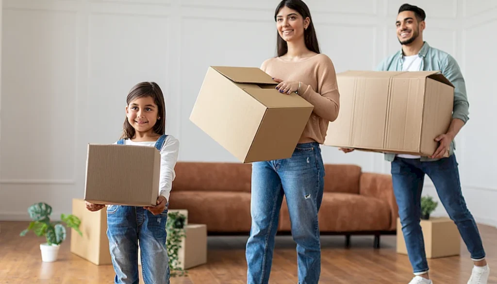 happy-young-arab-family-carrying-boxes-in-new-flat